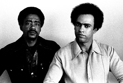 A black and white photograph of Black Panther Party founders Bobby Seale (left) and Huey P. Newton (right).